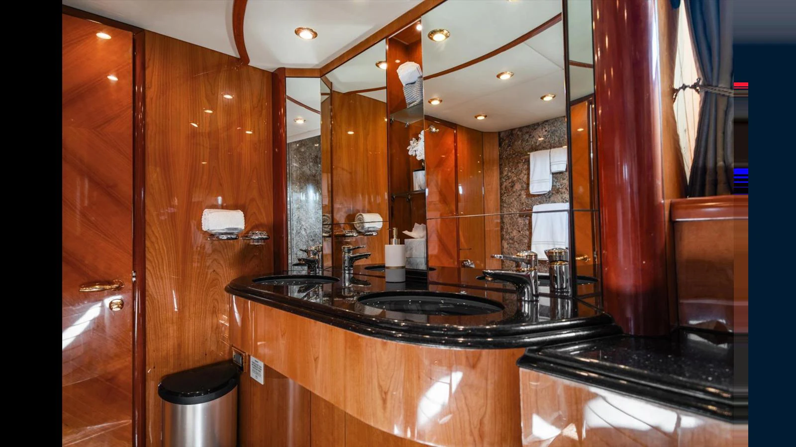 A luxurious yacht bathroom featuring elegant wood paneling and modern fixtures. aboard VANGUARD Yacht for Sale