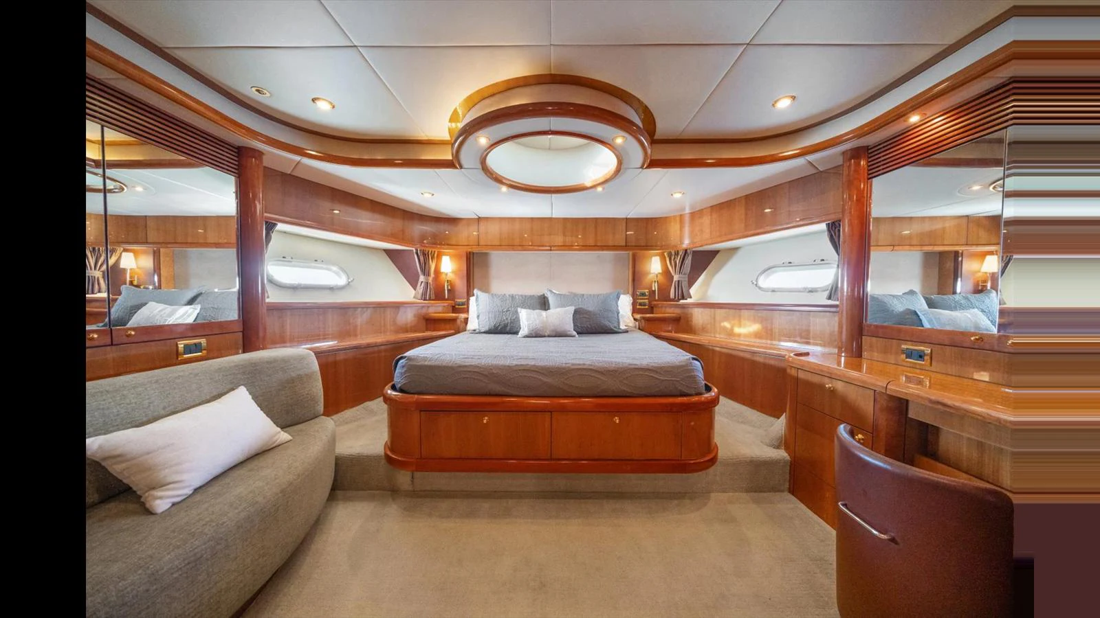 The master stateroom features a luxurious bed with elegant wood paneling and ample natural light. aboard VANGUARD Yacht for Sale