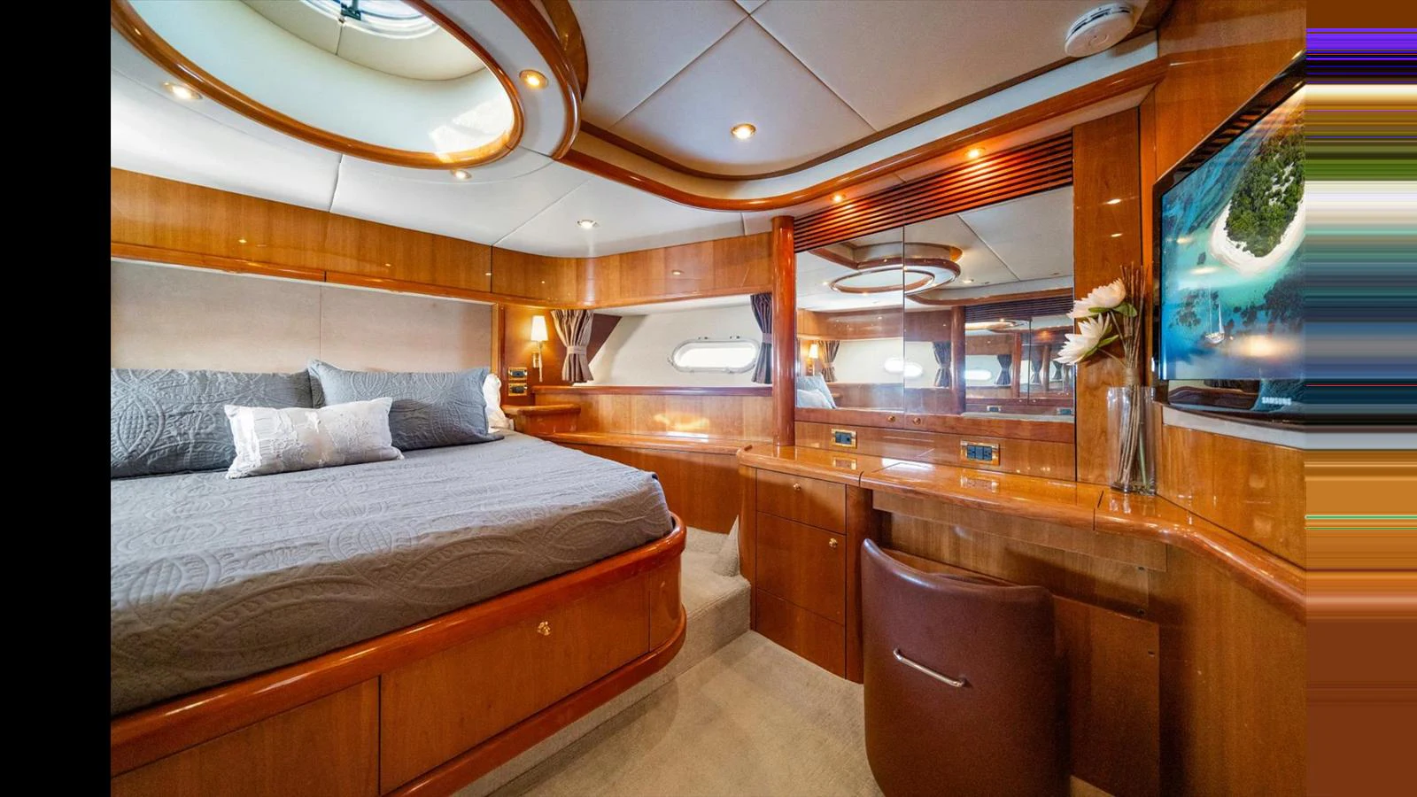 The master stateroom features a luxurious bed, ample storage, and elegant wood finishes. aboard VANGUARD Yacht for Sale