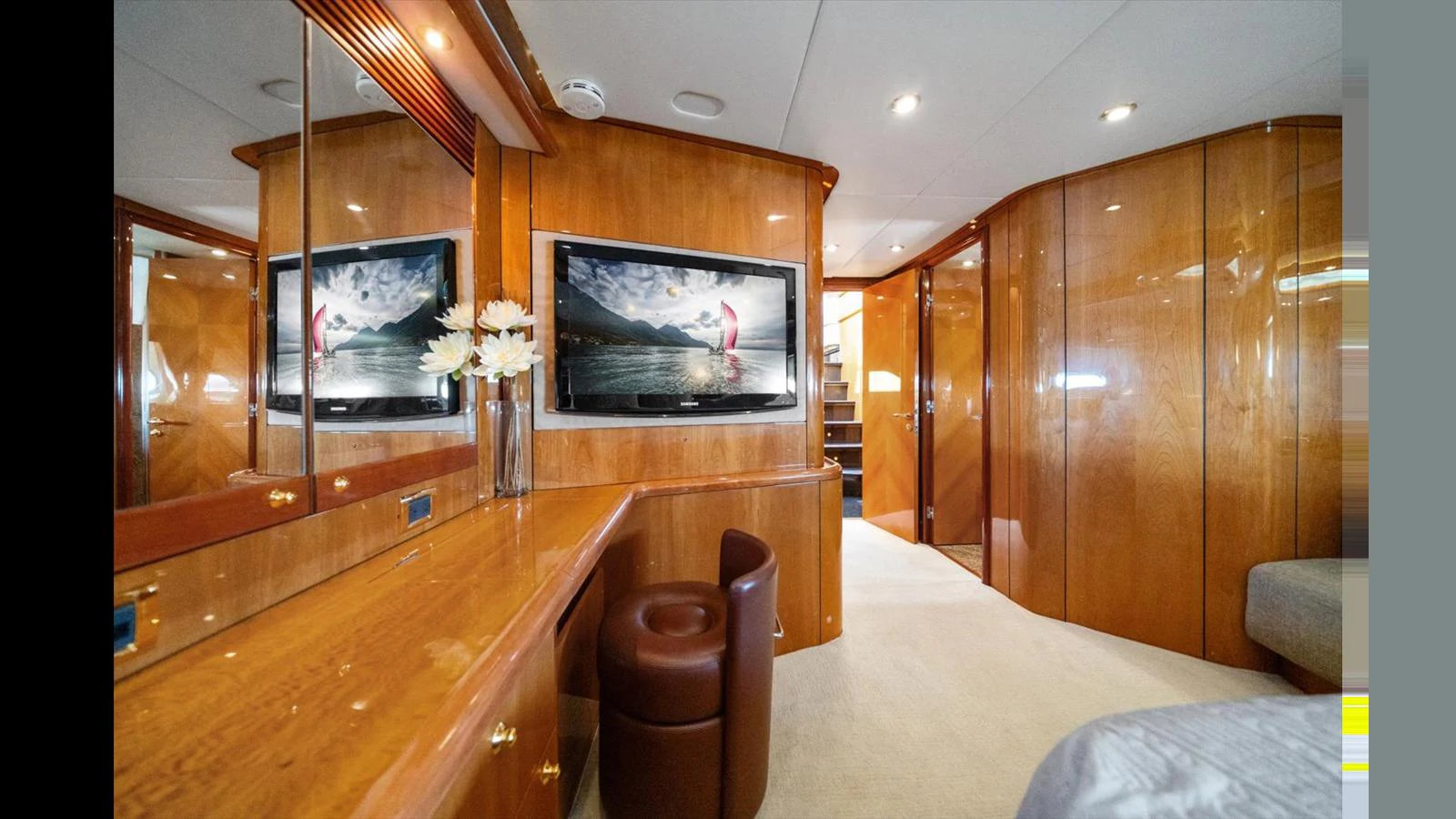 The stateroom features elegant wooden cabinetry and a comfortable seating area. aboard VANGUARD Yacht for Sale