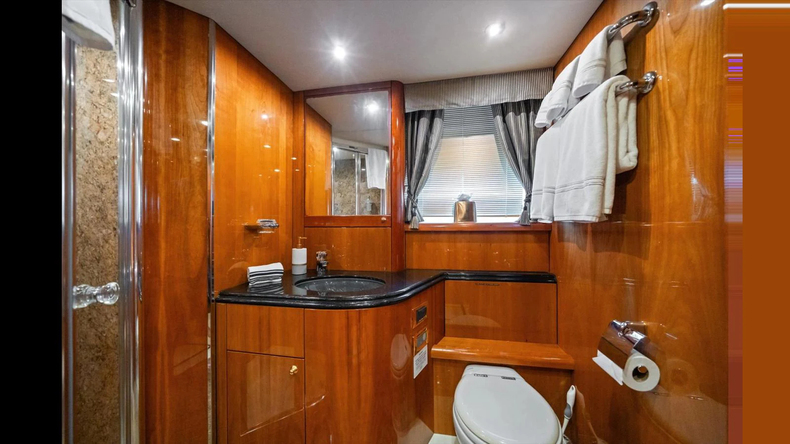 The yacht's bathroom features elegant wood paneling and modern fixtures. aboard VANGUARD Yacht for Sale