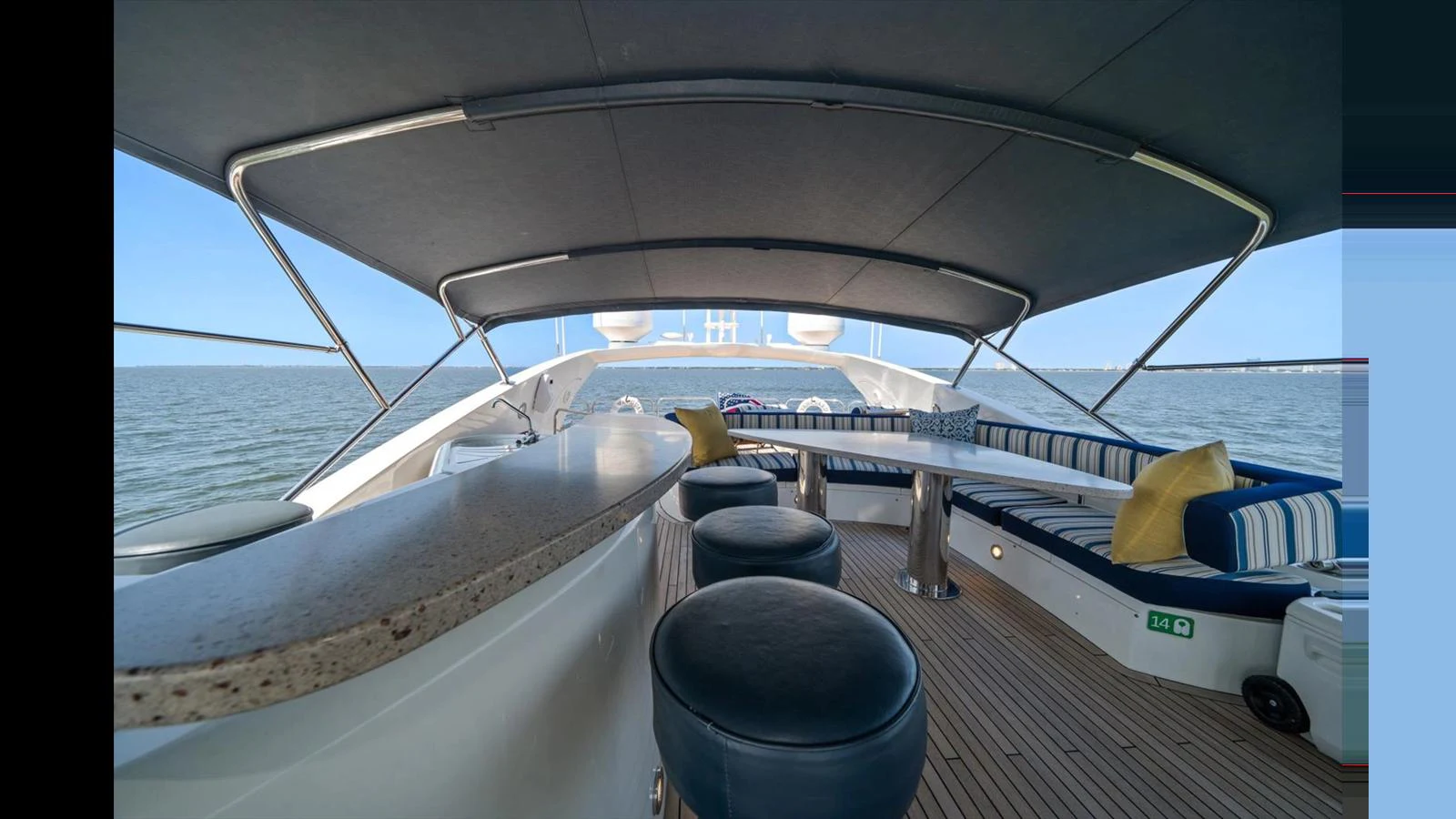 The flybridge offers a spacious and shaded area with comfortable seating and a bar, perfect for relaxation and socializing. aboard VANGUARD Yacht for Sale