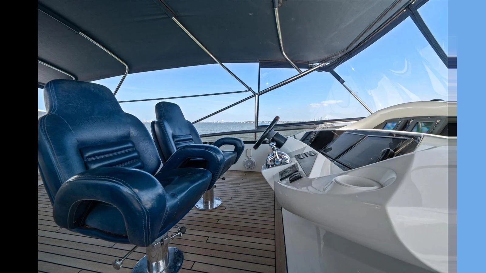 The helm area features sleek, modern controls and comfortable seating with a panoramic view. aboard VANGUARD Yacht for Sale