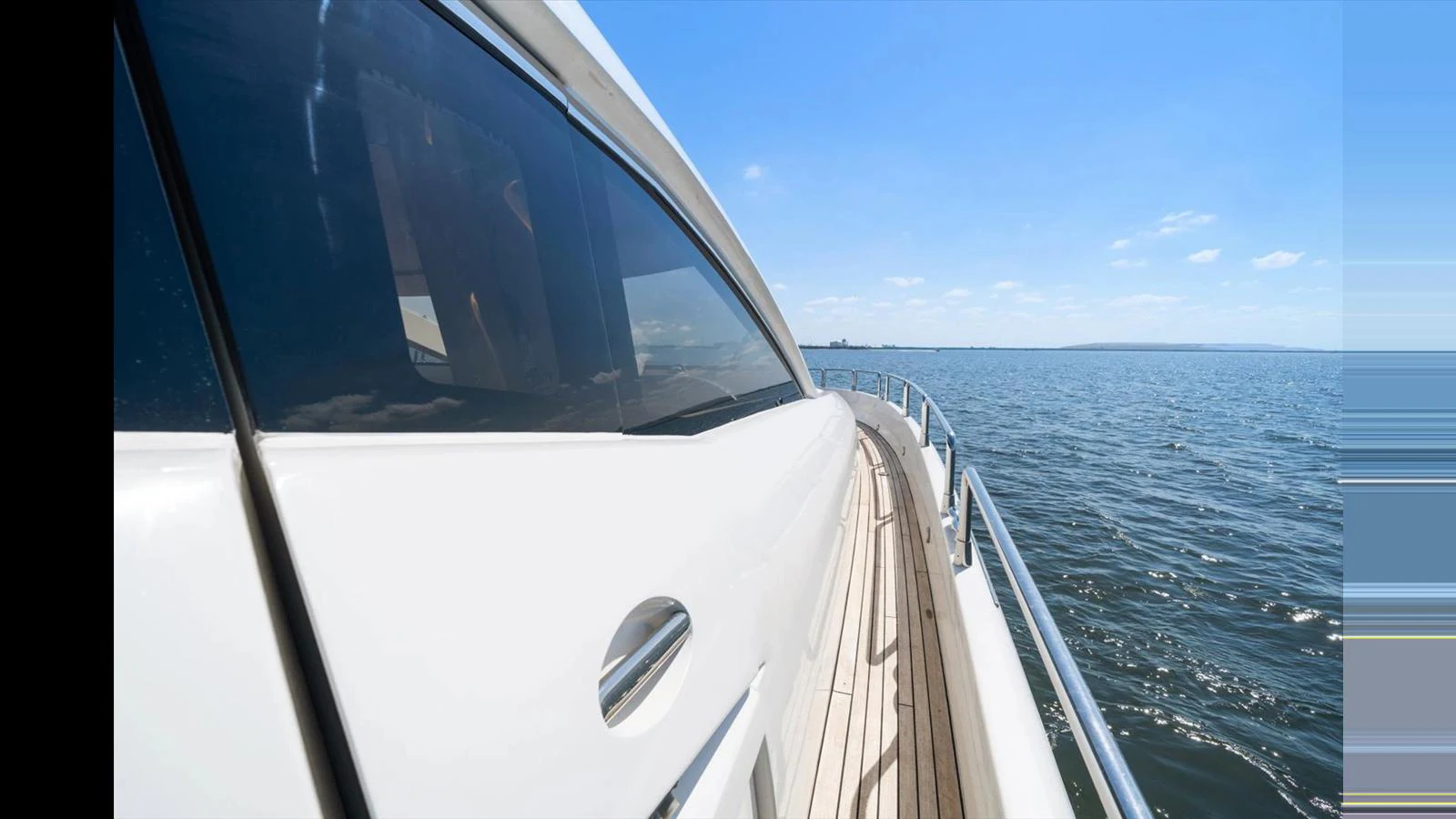 The yacht glides smoothly over calm waters, showcasing its sleek exterior design. aboard VANGUARD Yacht for Sale
