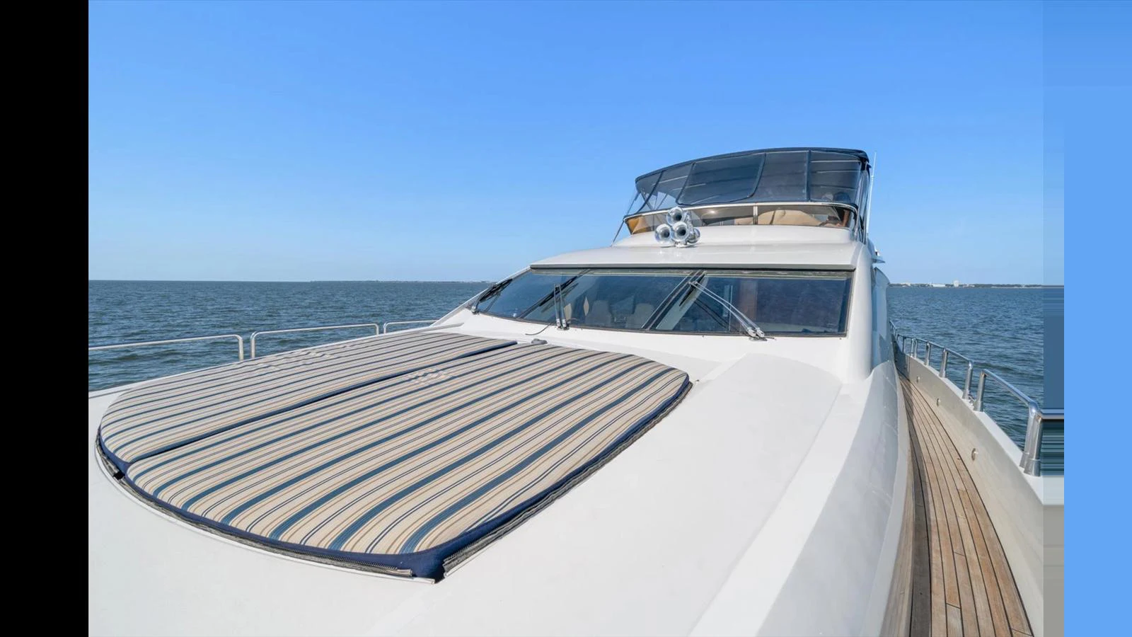The yacht's sleek exterior features a spacious foredeck with a striped sunpad, perfect for relaxation. aboard VANGUARD Yacht for Sale