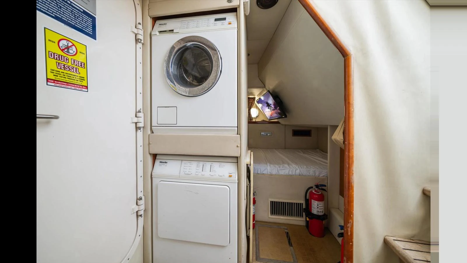 The yacht features a compact and efficient laundry area with a washer and dryer. aboard VANGUARD Yacht for Sale