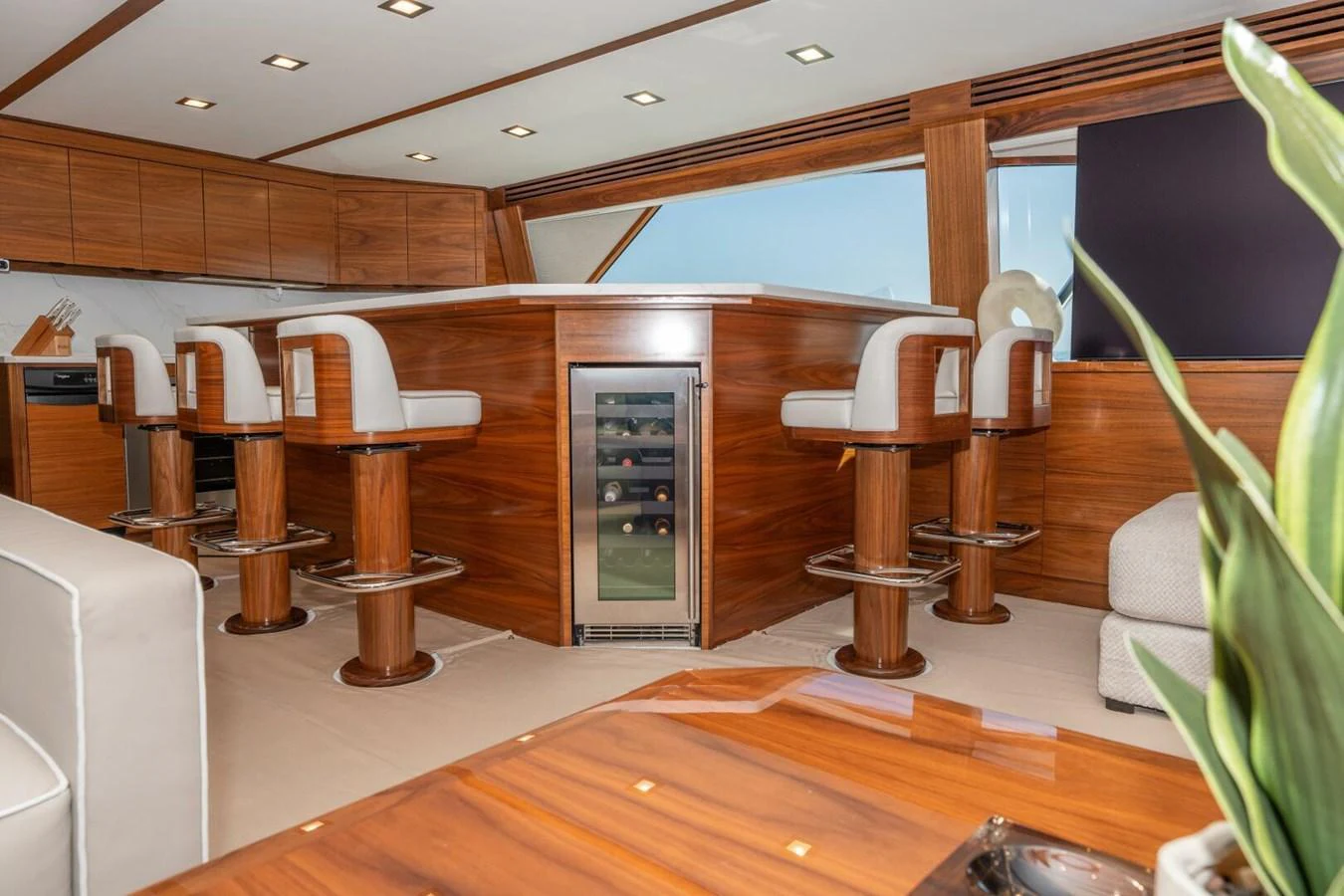 a modern kitchen with a bar and bar stools aboard ZATARA Yacht for Sale