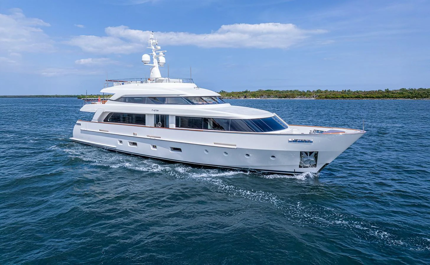 A sleek and modern yacht glides through calm waters under a clear blue sky. aboard BETTY JANE Yacht for Sale