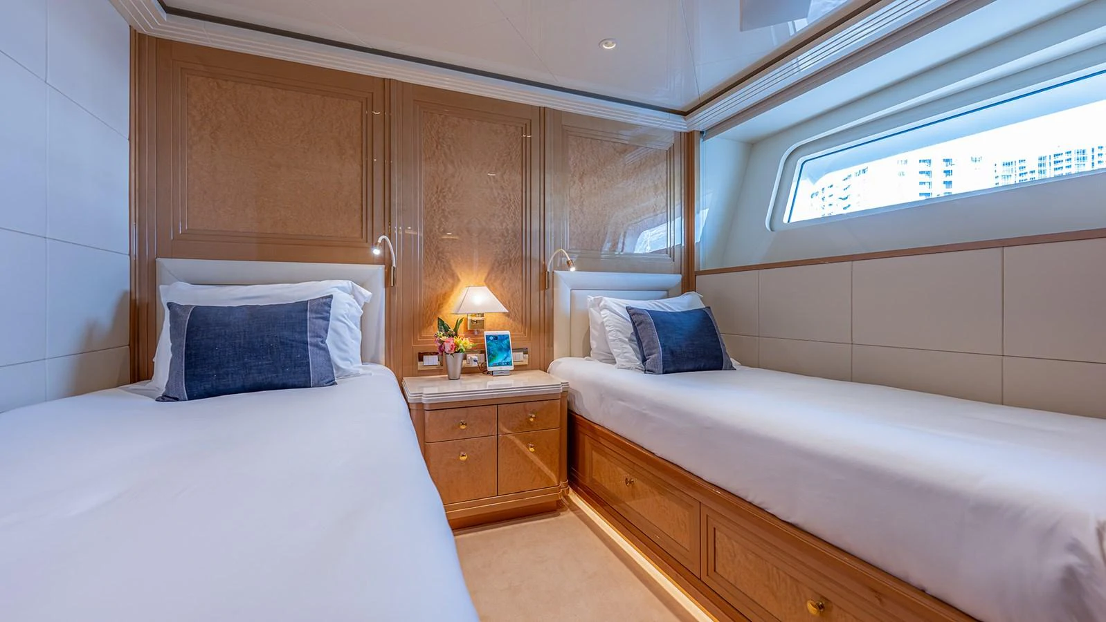 The twin stateroom features two comfortable single beds with elegant wooden cabinetry and a large window for natural light. aboard BETTY JANE Yacht for Sale