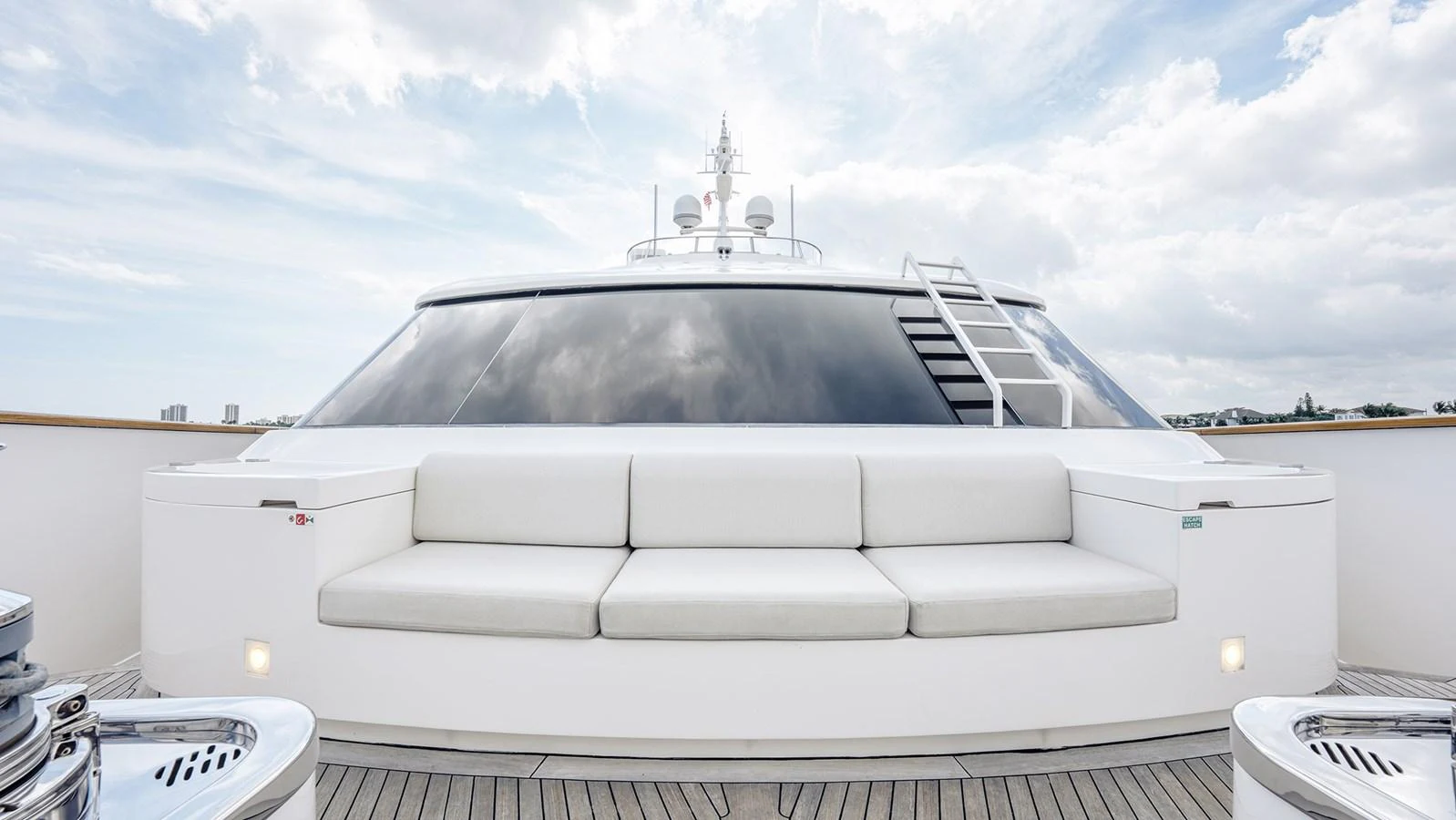 The foredeck features a sleek, modern seating area with plush white cushions and a panoramic view. aboard BETTY JANE Yacht for Sale