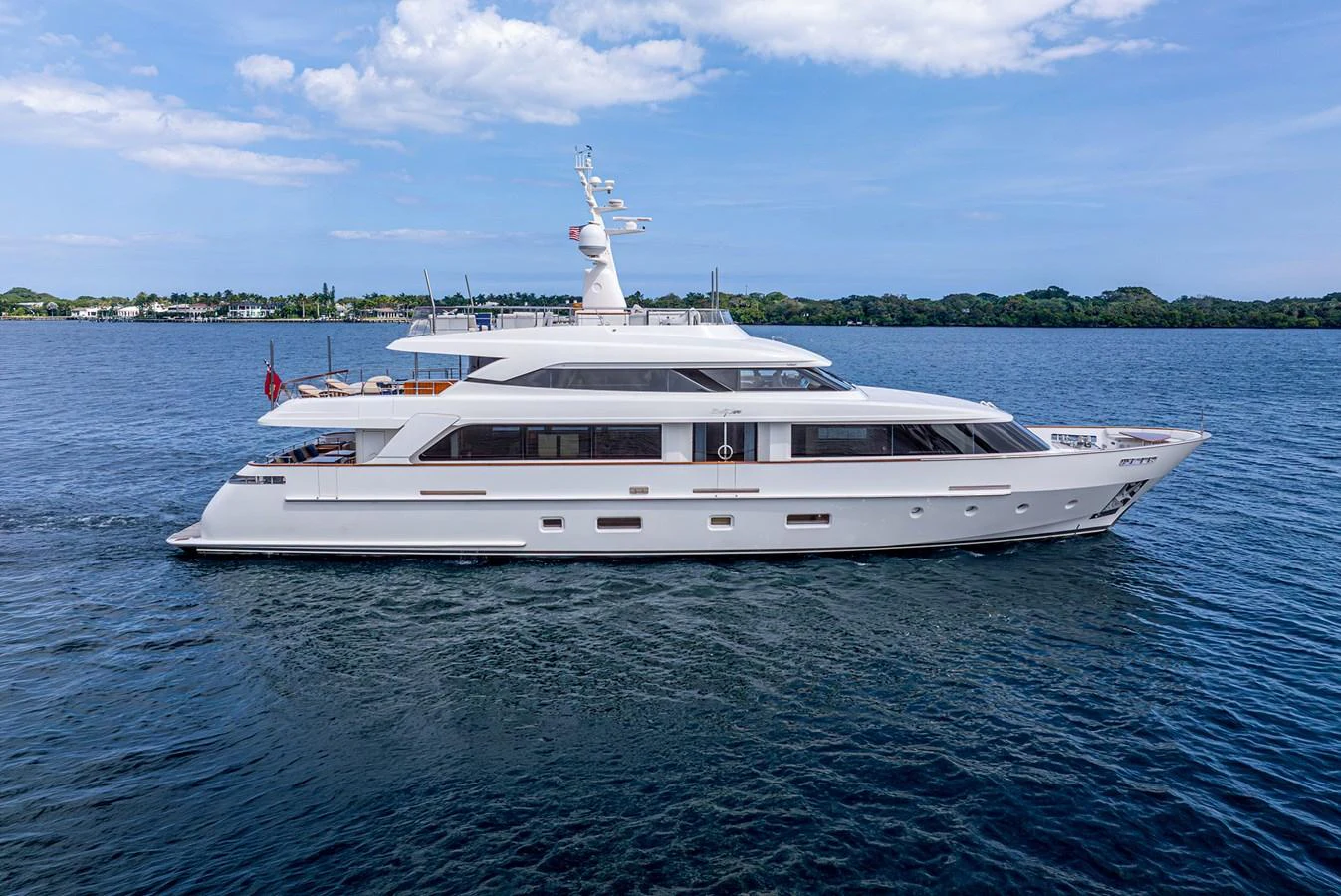 A sleek and elegant yacht glides smoothly on calm waters under a clear sky. aboard BETTY JANE Yacht for Sale