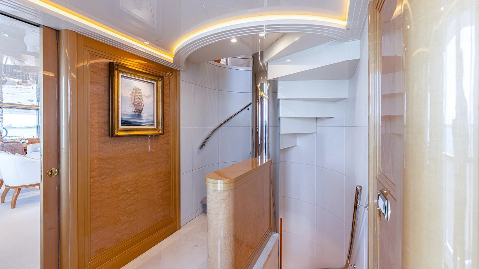 A luxurious interior staircase with elegant wood paneling and a framed painting on the wall. aboard BETTY JANE Yacht for Sale