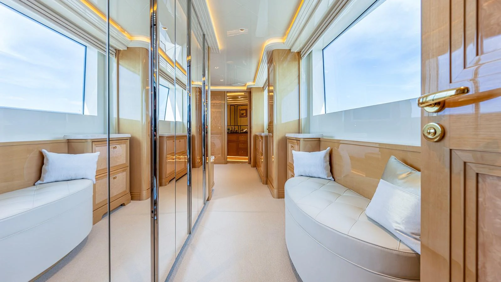 The yacht's interior hallway features luxurious seating and mirrored walls, creating an elegant and spacious ambiance. aboard BETTY JANE Yacht for Sale