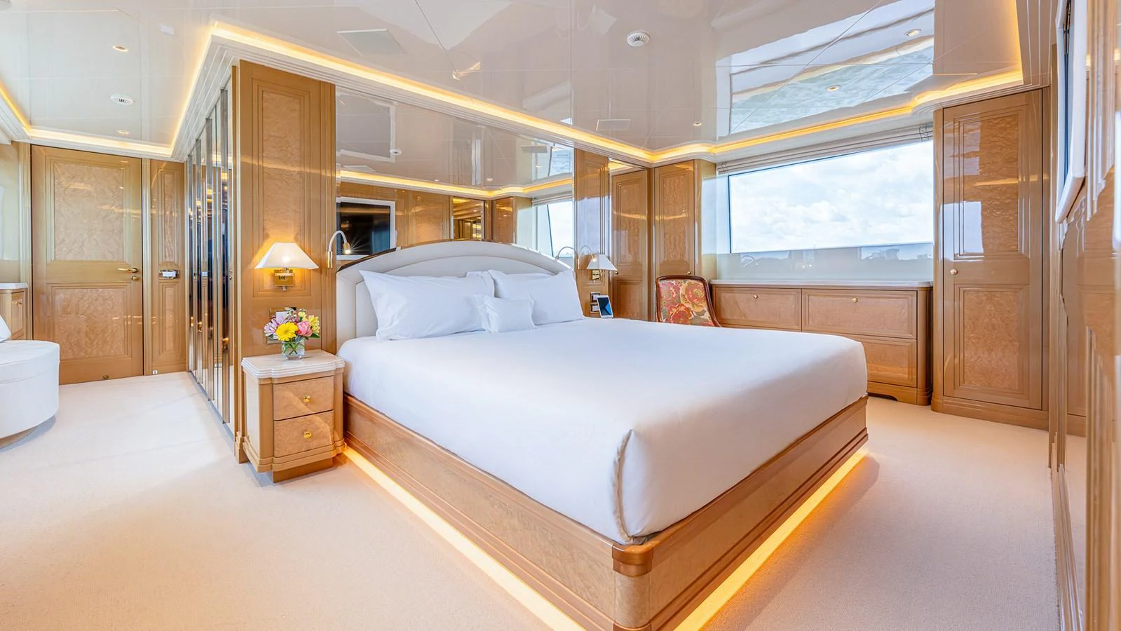 The master stateroom features a luxurious bed, elegant wood finishes, and ample natural light. aboard BETTY JANE Yacht for Sale