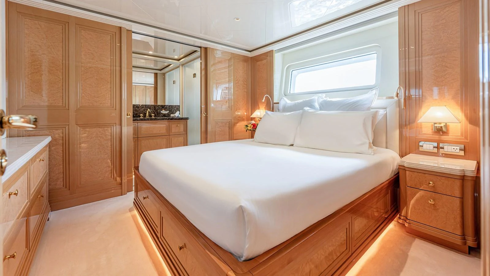 The master stateroom features a luxurious bed with elegant wood paneling and ample natural light. aboard BETTY JANE Yacht for Sale