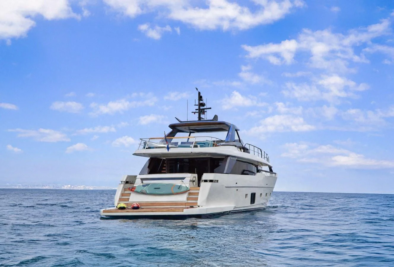 A luxurious yacht cruising on open water under a bright blue sky. aboard KAPUSHA Yacht for Sale