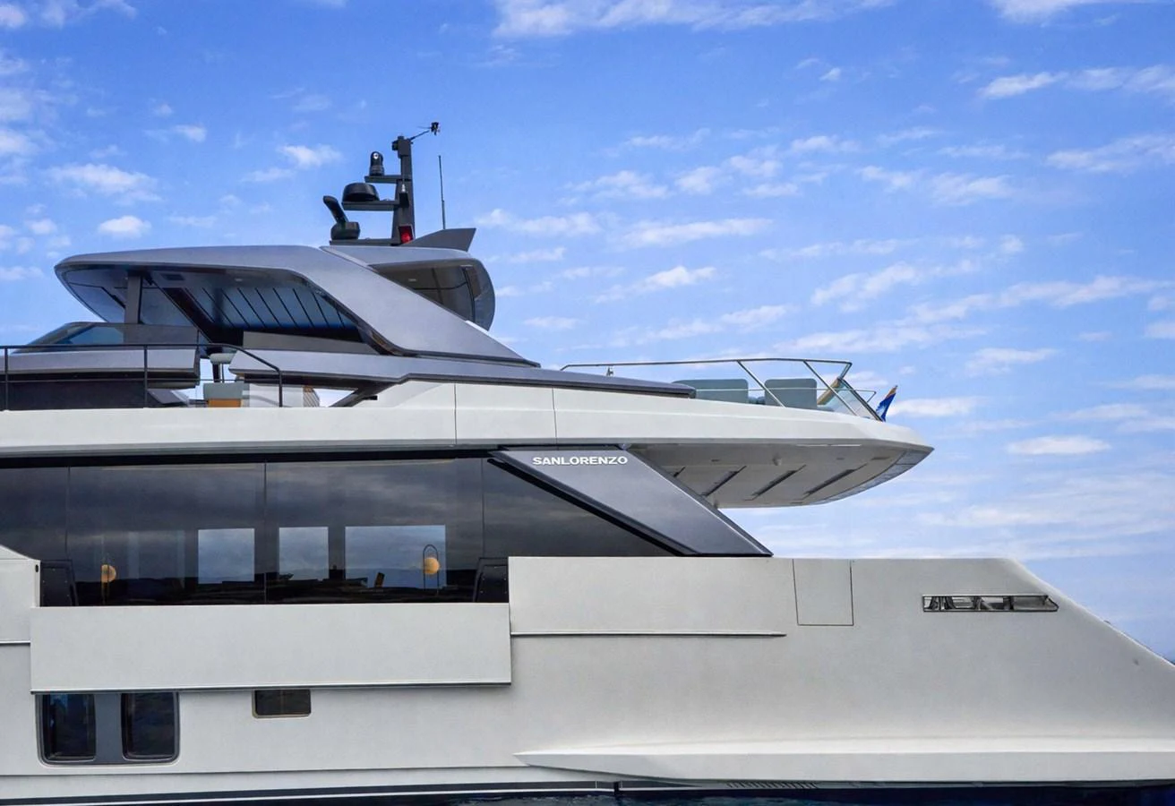 A sleek and modern yacht with a streamlined design against a backdrop of a partly cloudy sky. aboard KAPUSHA Yacht for Sale