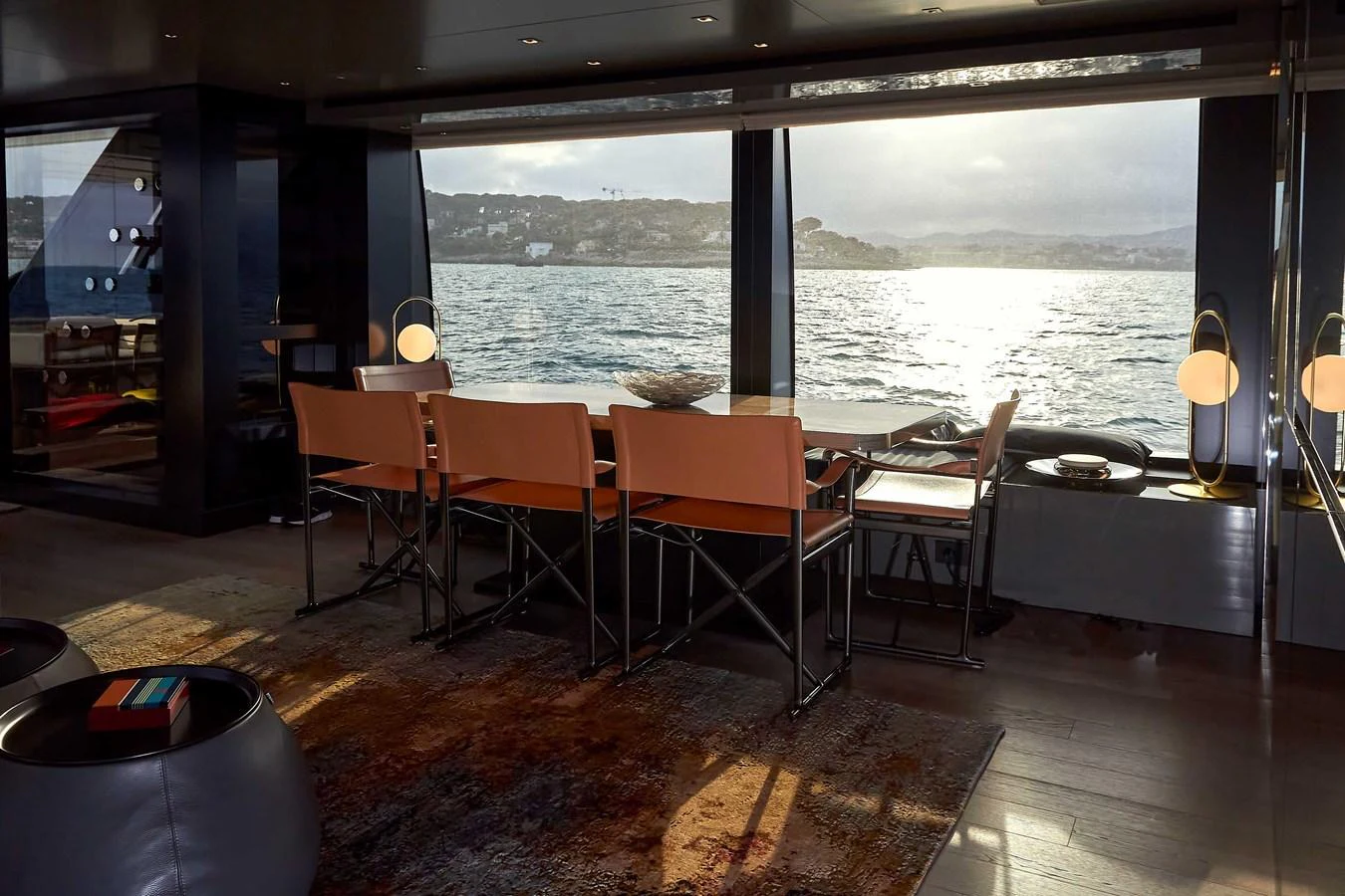 The yacht's dining area offers a stunning view of the water through large windows, creating a serene and elegant atmosphere. aboard KAPUSHA Yacht for Sale