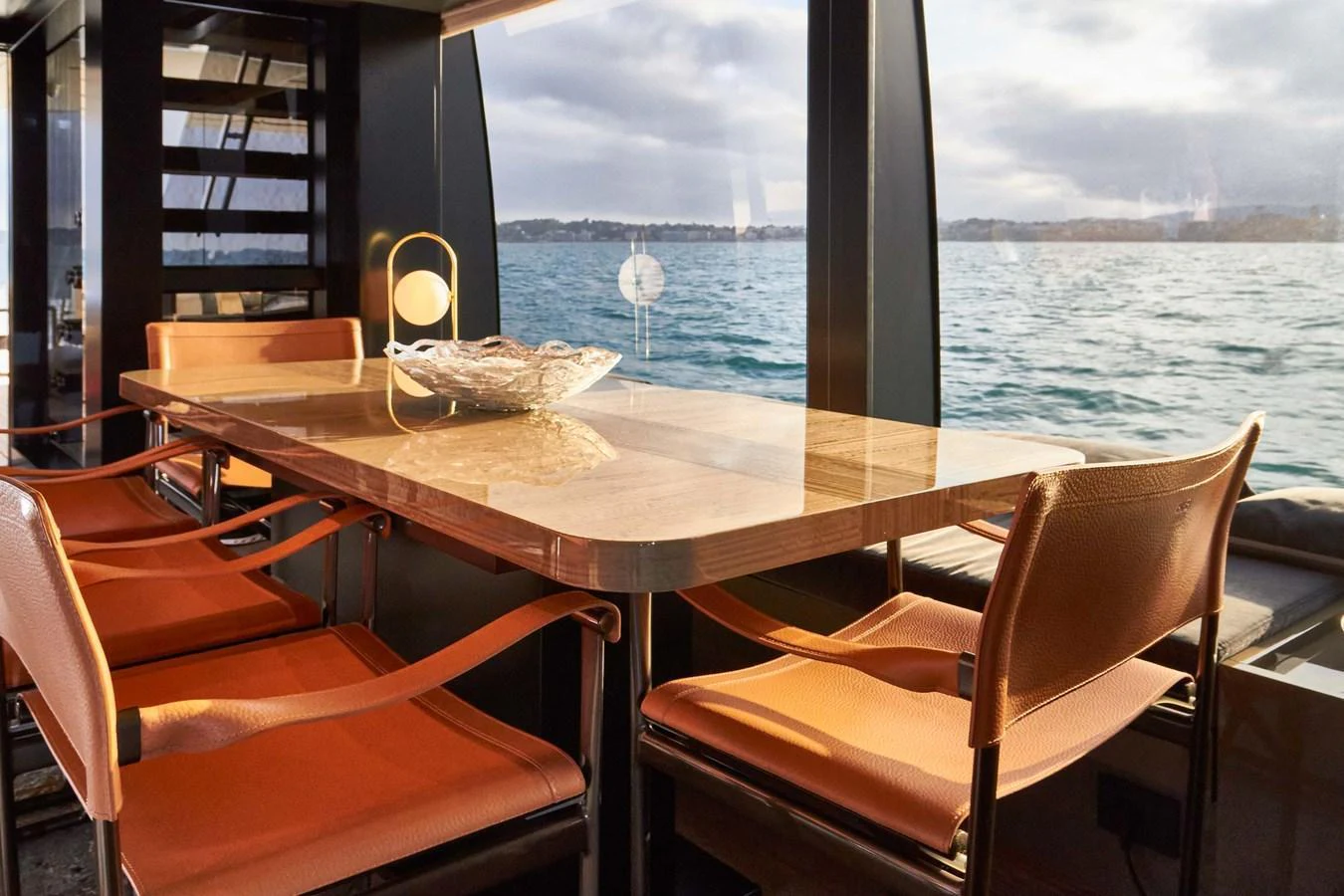 The yacht's dining area features a sleek table with comfortable seating and panoramic views of the water. aboard KAPUSHA Yacht for Sale
