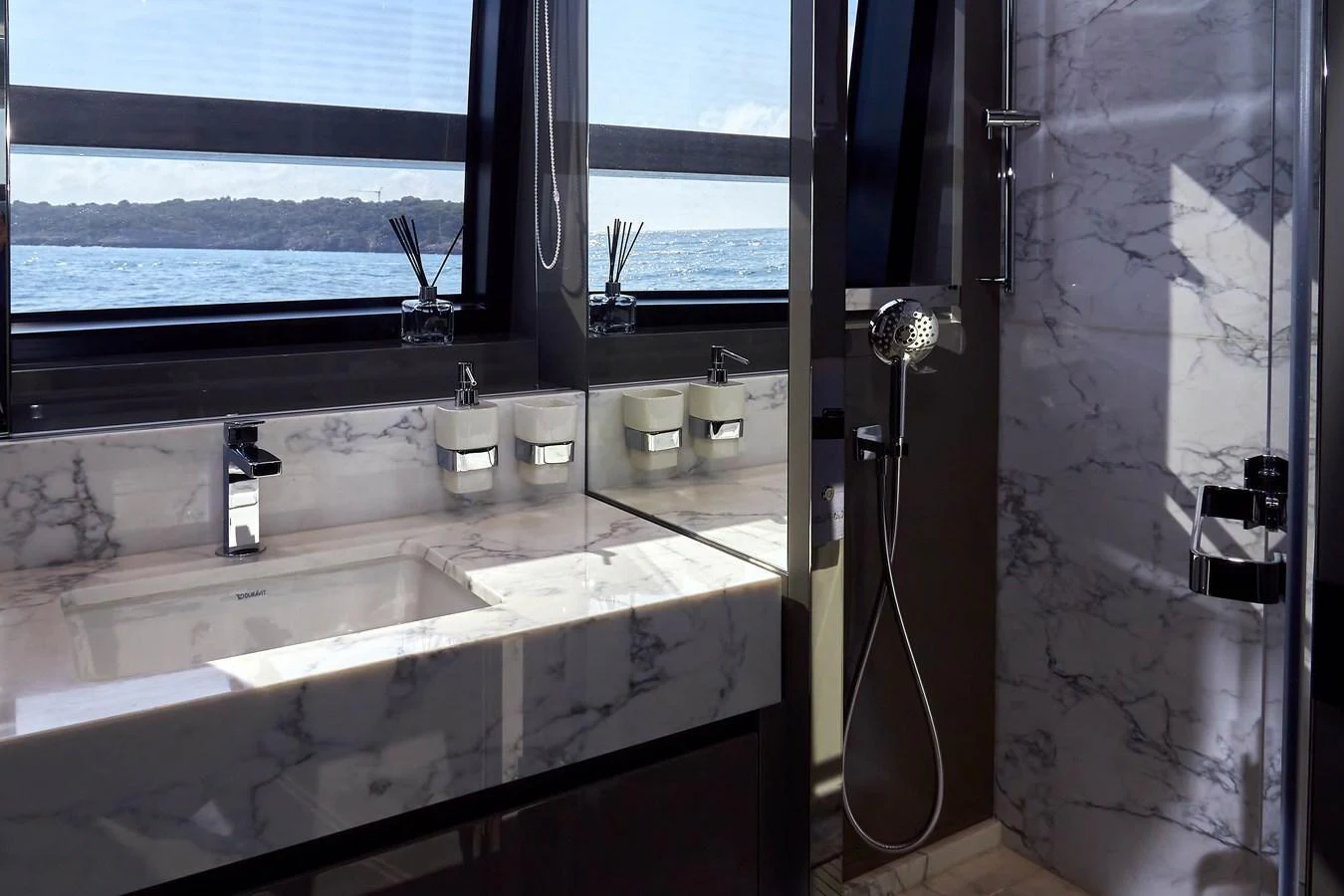 The yacht's bathroom features a sleek, modern design with marble surfaces and a large window offering a sea view. aboard KAPUSHA Yacht for Sale