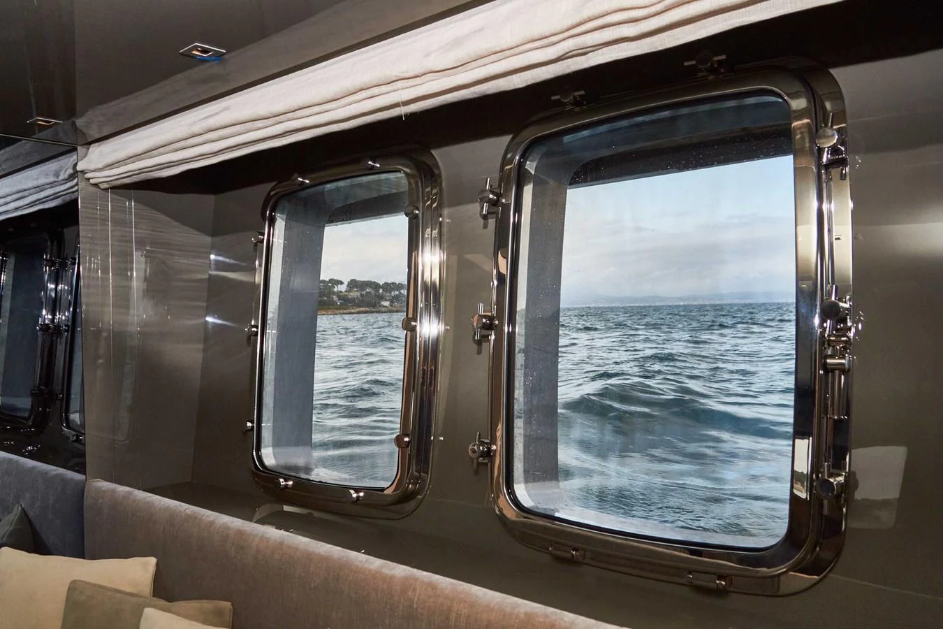 The image showcases the serene view of the sea through the yacht's windows from a cozy interior space. aboard KAPUSHA Yacht for Sale