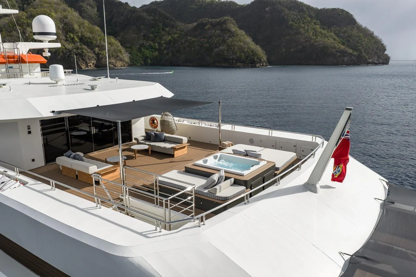 The yacht's aft deck features a luxurious lounging area with a jacuzzi, offering stunning views of the surrounding waters. aboard AKULA Yacht for Sale