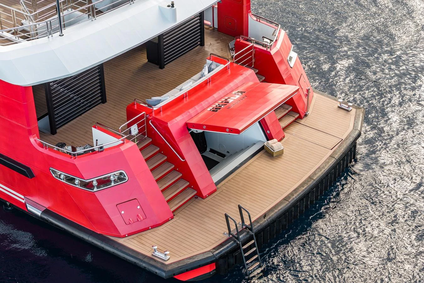 The yacht's aft deck features a striking red design with a spacious swim platform and steps leading up to the main deck. aboard AKULA Yacht for Sale