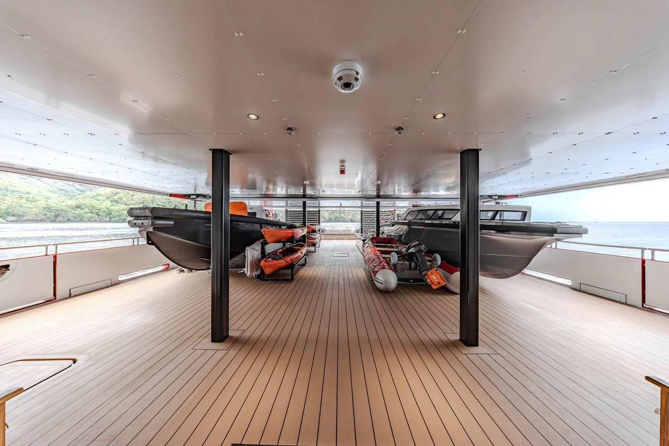 The yacht features a spacious tender garage with multiple boats and watercraft ready for adventure. aboard AKULA Yacht for Sale