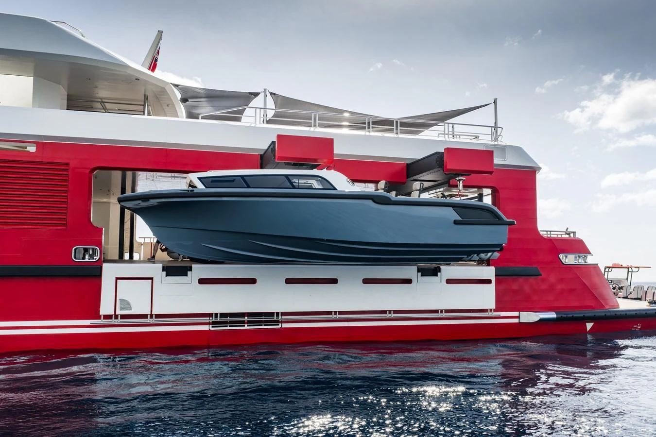 A sleek tender is securely stowed on the side of a vibrant red yacht, ready for deployment. aboard AKULA Yacht for Sale