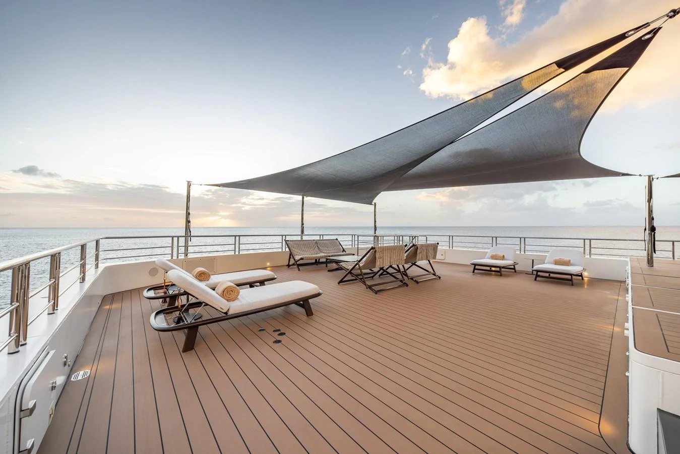 The sundeck offers a spacious area with lounge chairs and a shade canopy, perfect for relaxation. aboard AKULA Yacht for Sale
