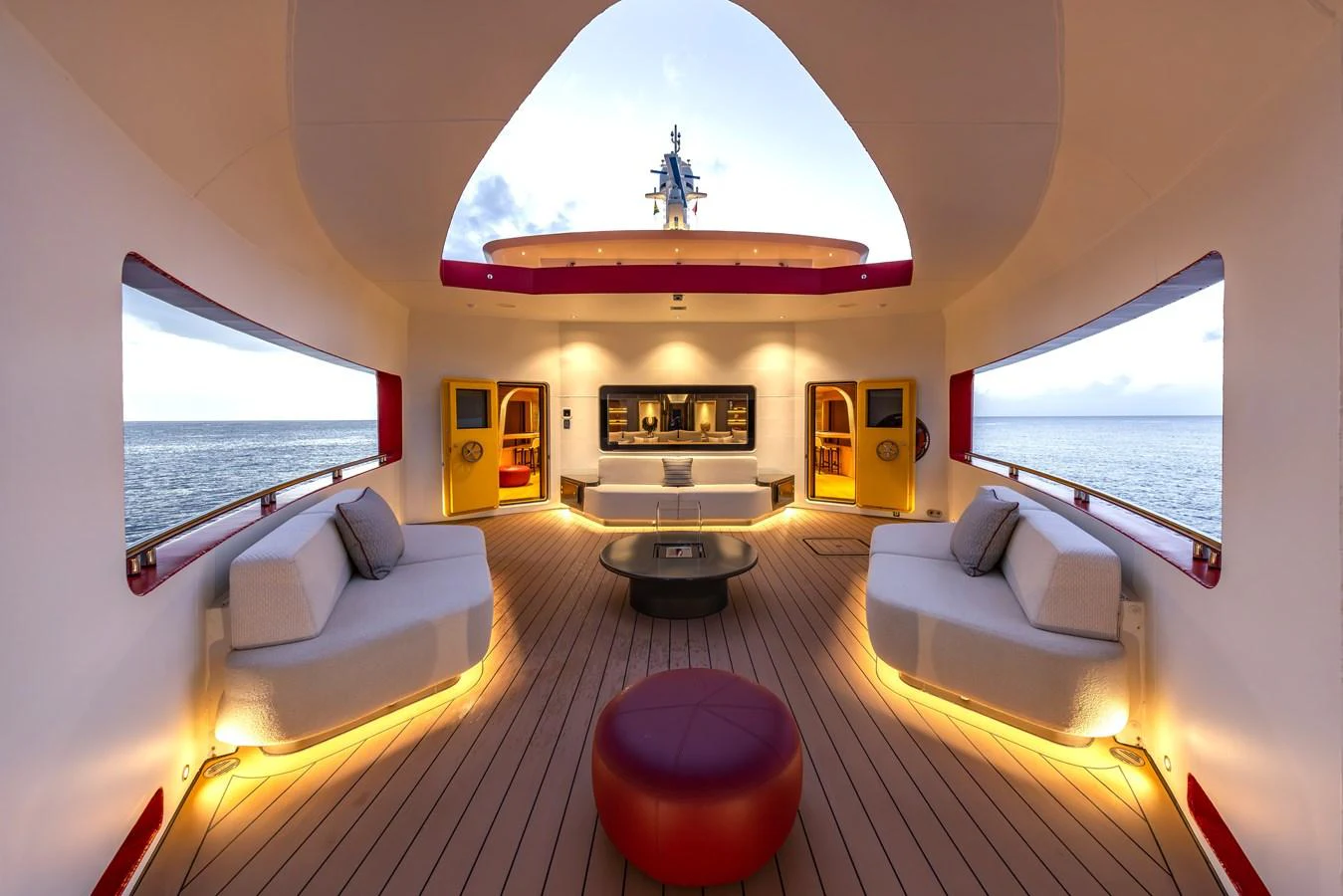 The aft deck features a spacious and stylish lounging area with modern furnishings and ambient lighting. aboard AKULA Yacht for Sale
