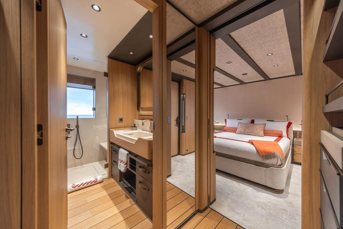 A luxurious stateroom with an ensuite bathroom, featuring modern wood finishes and elegant decor. aboard AKULA Yacht for Sale