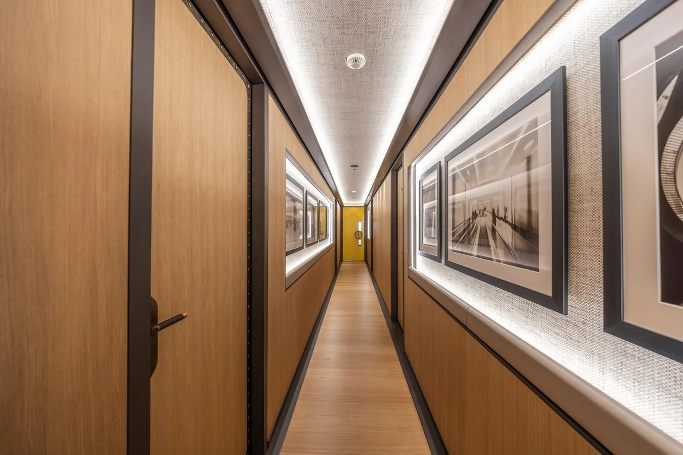 A sleek and modern hallway adorned with framed artwork and warm lighting. aboard AKULA Yacht for Sale
