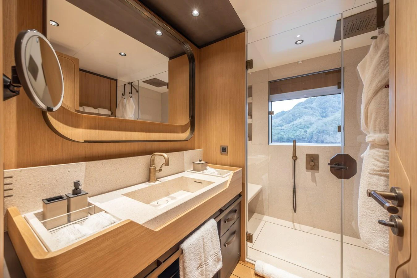 The yacht's bathroom features modern fixtures and a spacious shower with a scenic view. aboard AKULA Yacht for Sale