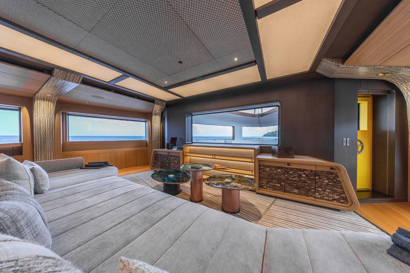 The salon features luxurious seating with panoramic windows offering stunning ocean views. aboard AKULA Yacht for Sale