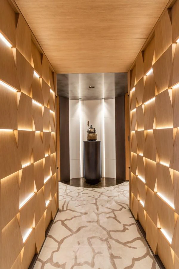 A luxurious hallway with modern lighting and a stylish sculpture at the end. aboard AKULA Yacht for Sale