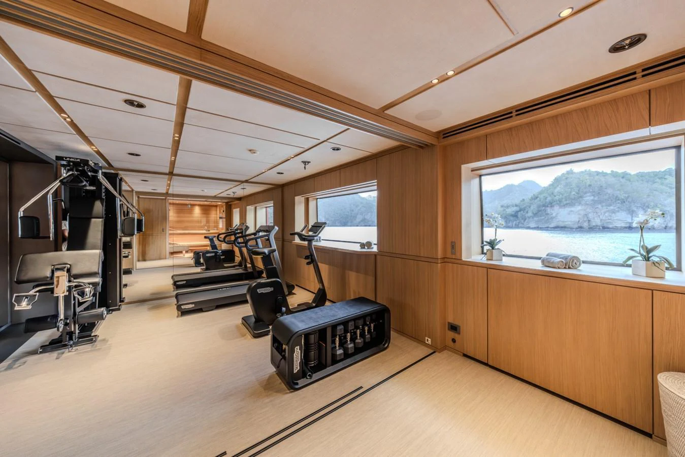The yacht's gym offers a well-equipped space with stunning sea views through large windows. aboard AKULA Yacht for Sale