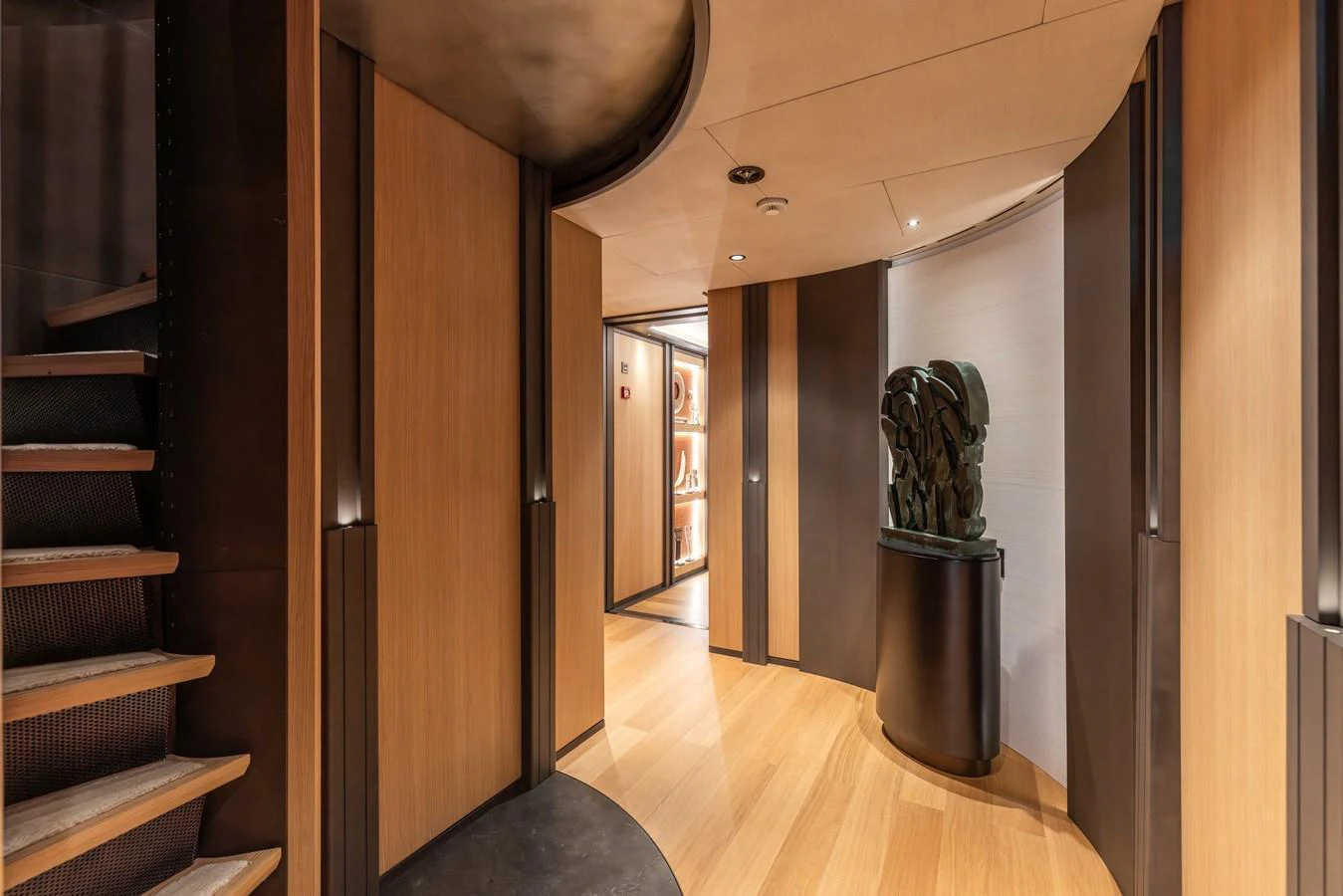 The yacht's interior features a stylish hallway with elegant wood paneling and modern decor. aboard AKULA Yacht for Sale