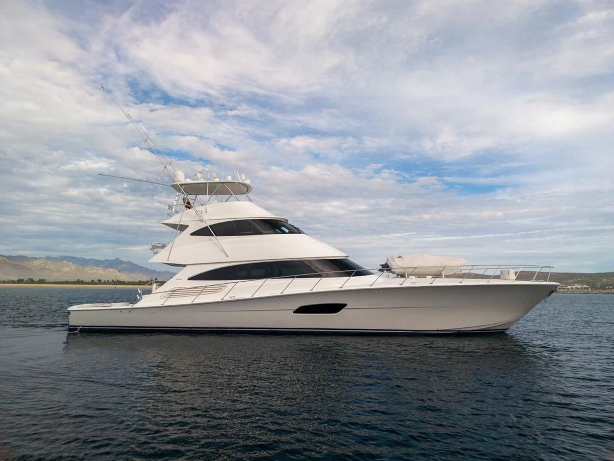 A sleek and modern yacht glides gracefully on calm waters under a partly cloudy sky. aboard MARLIN MAGIC Yacht for Sale