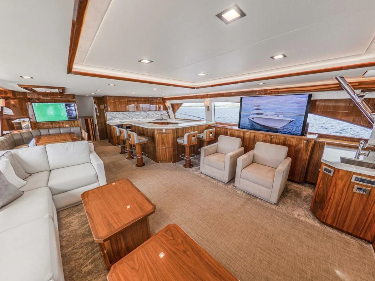 The salon features luxurious seating, a bar area, and large windows offering stunning views. aboard MARLIN MAGIC Yacht for Sale