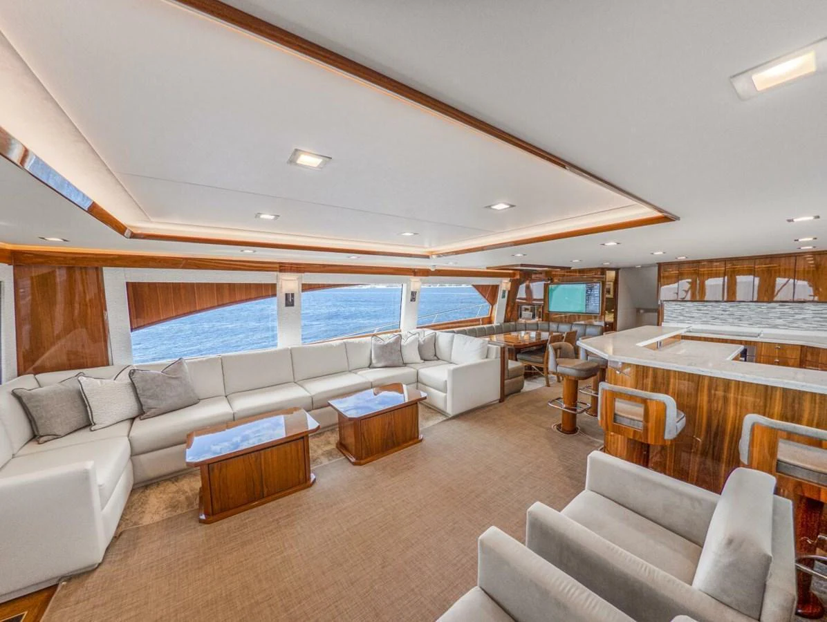 The spacious salon features luxurious seating and panoramic windows with stunning ocean views. aboard MARLIN MAGIC Yacht for Sale