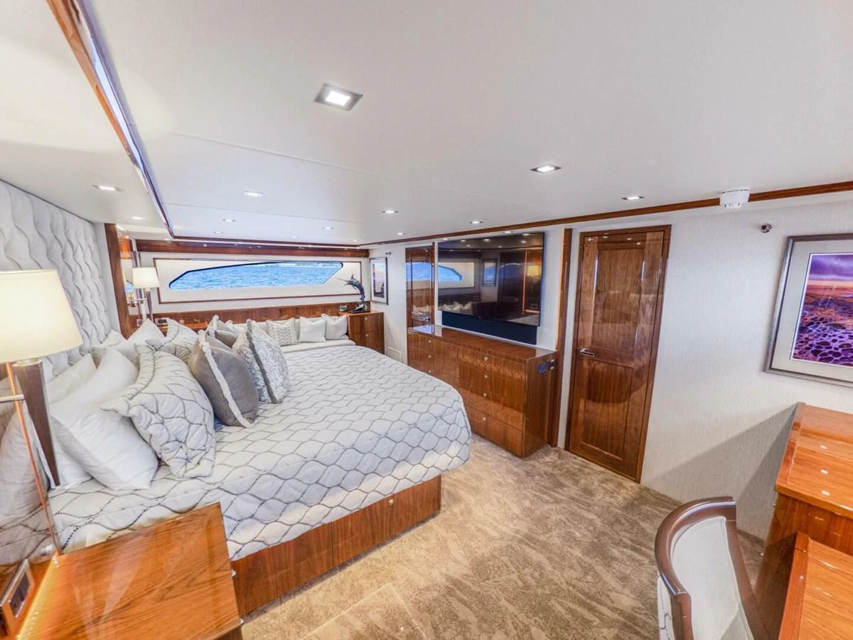 The master stateroom features a spacious bed with luxurious bedding and elegant wood finishes. aboard MARLIN MAGIC Yacht for Sale