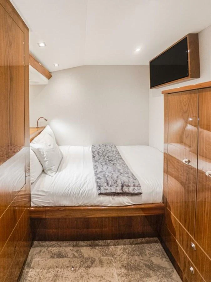 The stateroom features a cozy bed with luxurious bedding and ample storage space. aboard MARLIN MAGIC Yacht for Sale