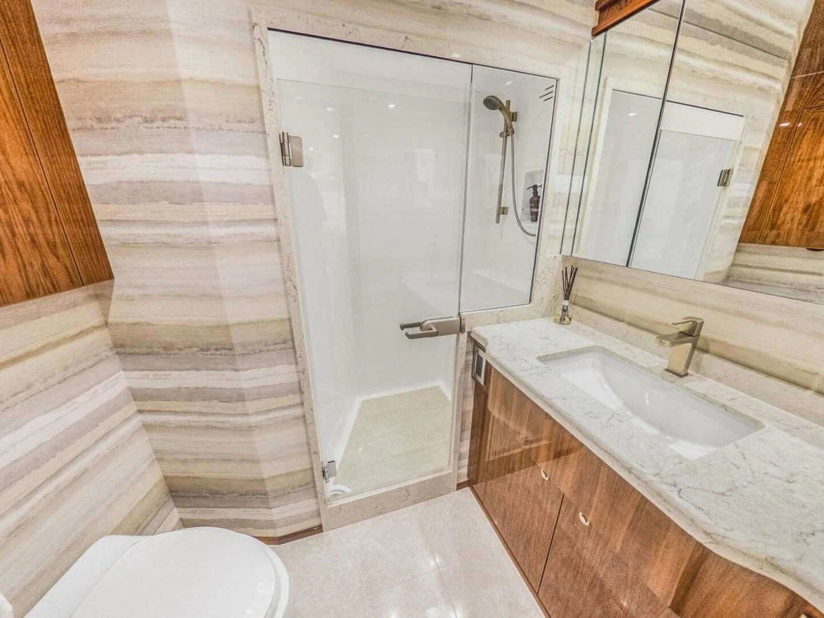 The yacht's bathroom features elegant marble surfaces and modern fixtures. aboard MARLIN MAGIC Yacht for Sale