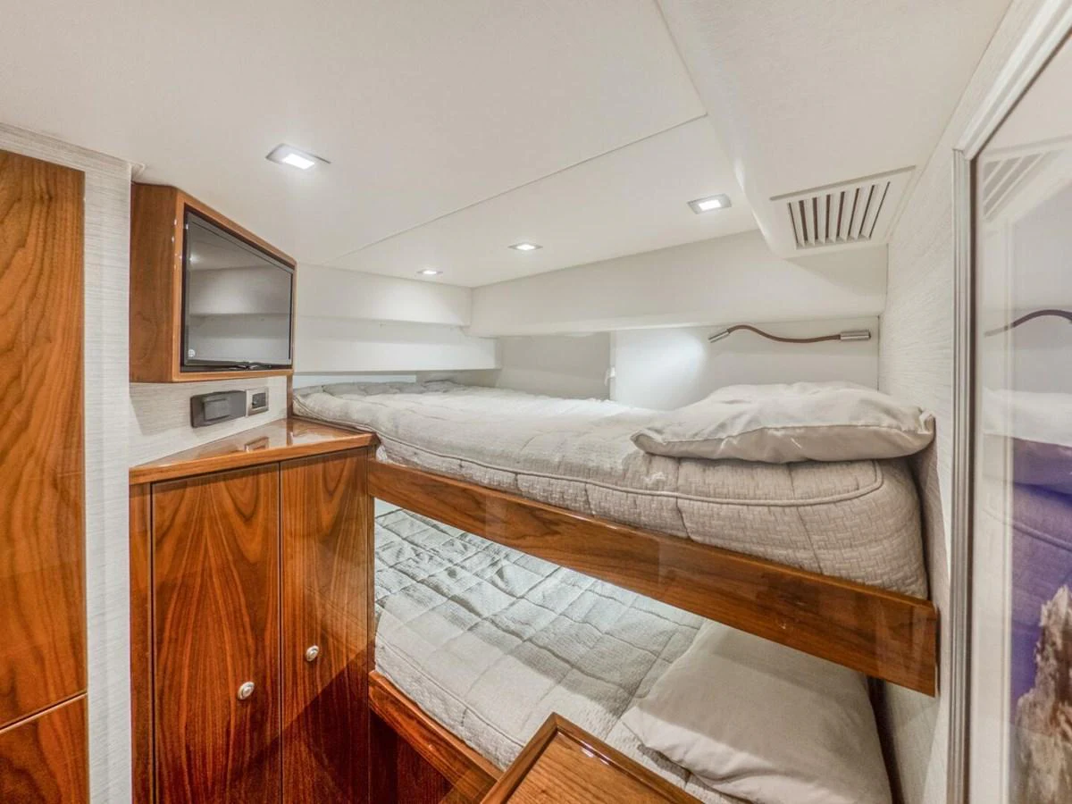 The cozy bunk cabin features polished wood finishes and modern lighting. aboard MARLIN MAGIC Yacht for Sale