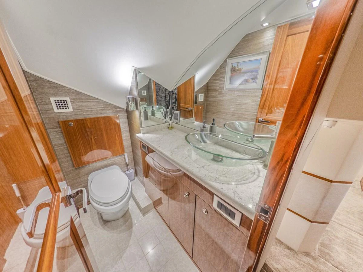 The yacht's bathroom features elegant wood finishes and modern fixtures, creating a luxurious and comfortable space. aboard MARLIN MAGIC Yacht for Sale
