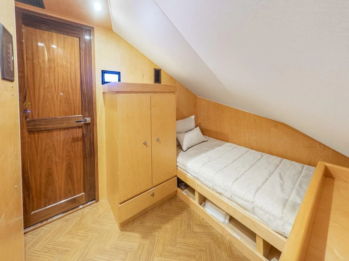 A cozy cabin with a single bed and wooden furnishings. aboard MARLIN MAGIC Yacht for Sale