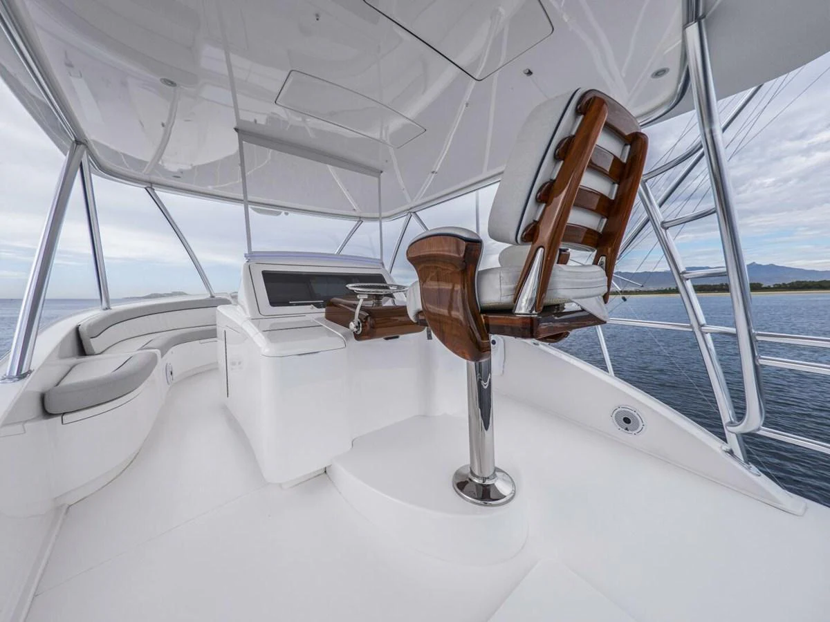 The yacht's helm features a sleek, modern design with a polished wooden captain's chair and state-of-the-art navigation equipment. aboard MARLIN MAGIC Yacht for Sale