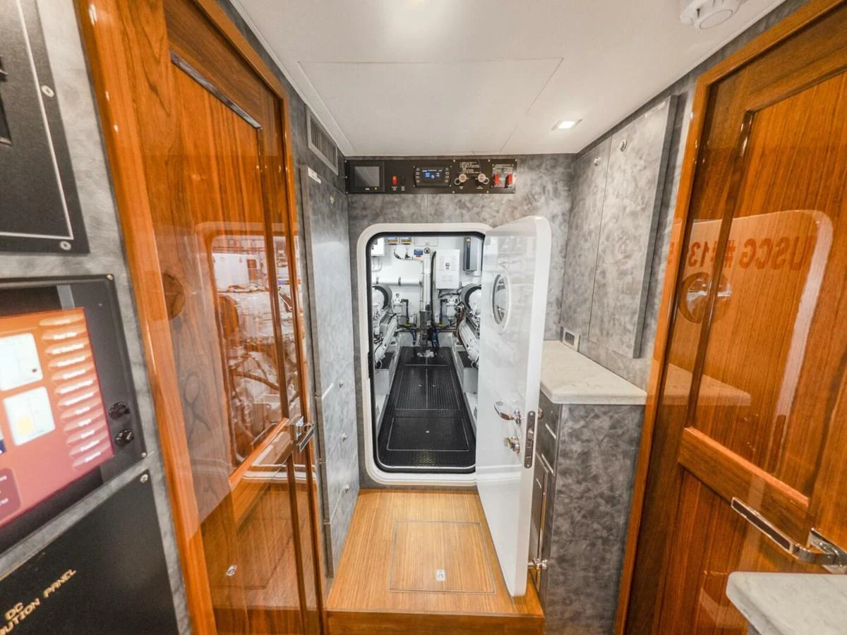 The image showcases a well-maintained interior passageway leading to the engine room. aboard MARLIN MAGIC Yacht for Sale