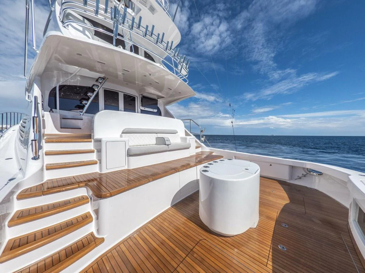 The aft deck features elegant wooden flooring and comfortable seating with a stunning ocean view. aboard MARLIN MAGIC Yacht for Sale